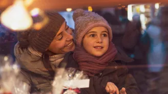 Mom and daughter at a holiday market.