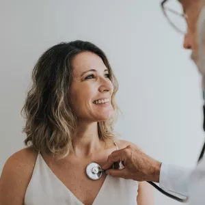 Doctor Listening to Female Patient Heartbeat