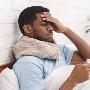 A man feeling under the weather in bed.