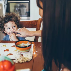 A young boy messily eats his breakfast