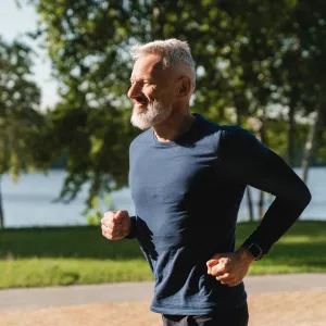 Senior Man Jogging in Park by Lake