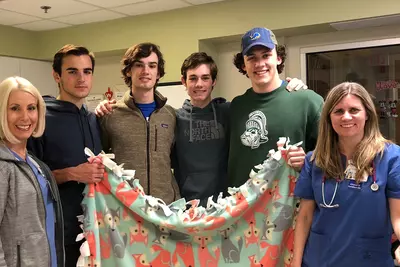 UCMAH Hinsdale Junior Board group of students with nurses holding blanket