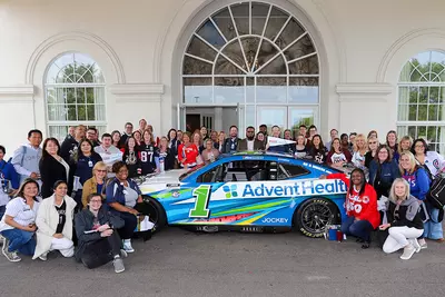 People Taking Picture in Front of Building With UChicago Medicine AdventHealth Car