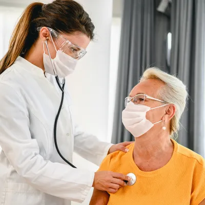 A doctor listens to a patient's breathing with a stethoscope 