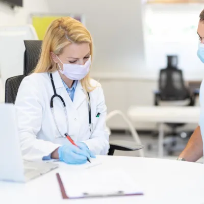 A Doctor Goes Over Details of a Case with the Patient while Sitting at a Round Table.