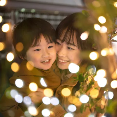 A Mother and Son Enjoy Christmas Lights Outside in the Winter Weather