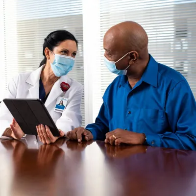 A Man Speaks to His Doctor in a Patient Room.