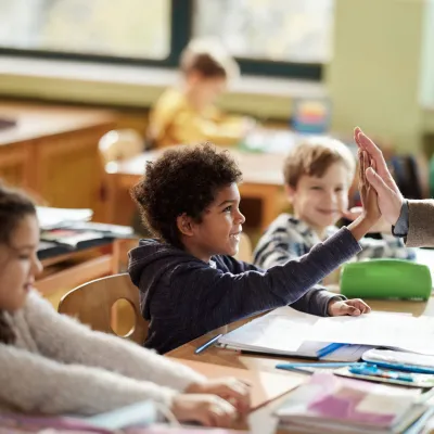 A Student High Fives His Teacher in the Classroom