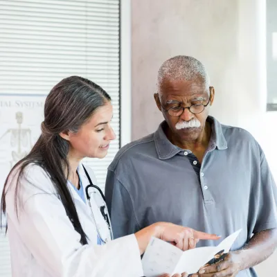 A Doctor Goes Over a Brochure with Her Senior Patient 