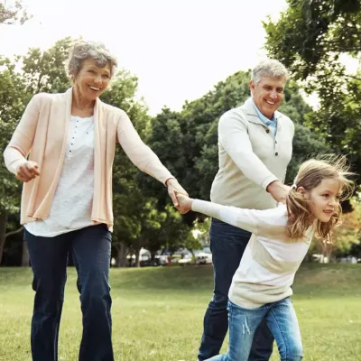 Senior Couple Playing With Grandchild in Park