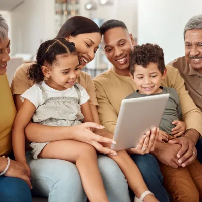 Hispanic Latino family on couch looking at iPad together.