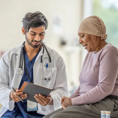 Doctor explaining to an older woman cancer patient her test results.