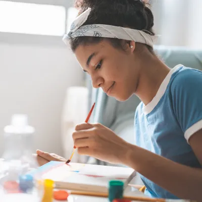 Young Adult Girl Painting on Canvas