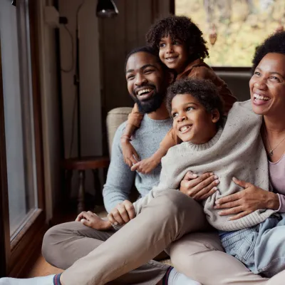 A happy African-American family looking out the window