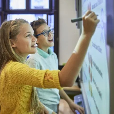 Two Middle School Kids Writing on Board