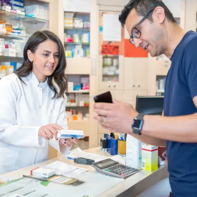 Man Talking to Pharmacist Showing Something on His Phone