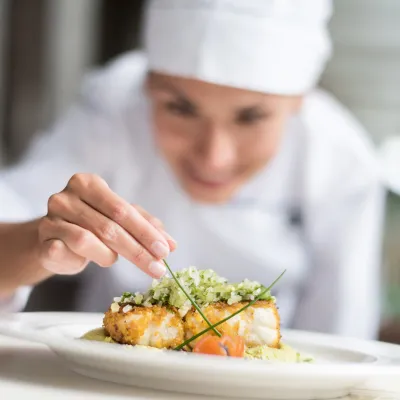 Woman Chef Garnishing Plate of Food