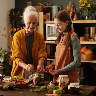 Grandmother and granddaughter cooking together in a kitchen.