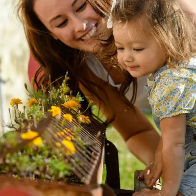 Mother and daughter smelling flowers. 