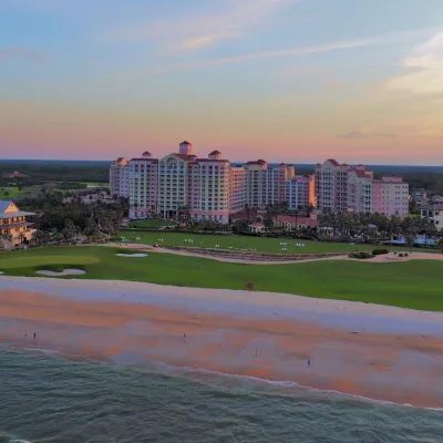 A sunset, tropical scene of a hotel resort next to the beach