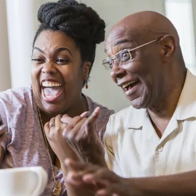 A couple laughing on a video call.