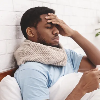 A man feeling under the weather in bed.