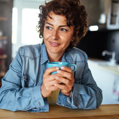 Woman holding cup of tea in living room