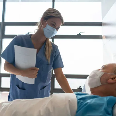 Nurse Checks on an Patient in His Hospital Room.