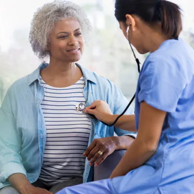 Female Doctor Listening to Woman's Heart