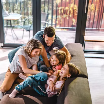 Parents playing with children at home in living room.