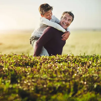 Father carrying son on back.