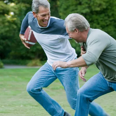 Senior men playing backyard football.