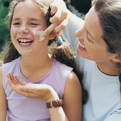 Mom applying sunscreen to daughter