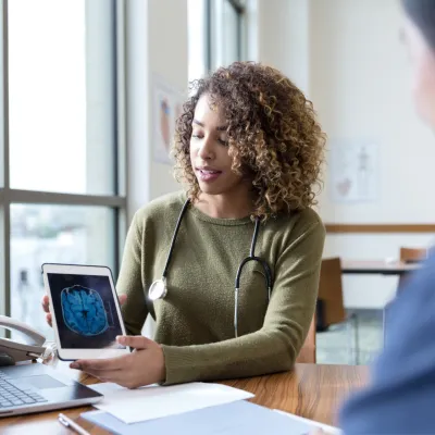 A patient and physician looking at a laptop screen