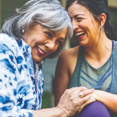 Two women holding hands and laughing.