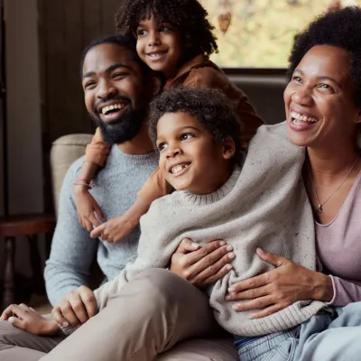  Family sitting indoors by window laughing
