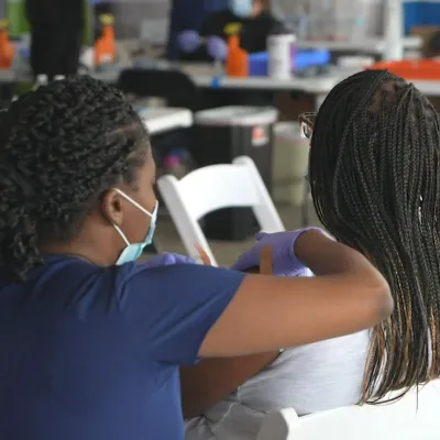 A nurse administers a vaccine to a patient at a community vaccination event