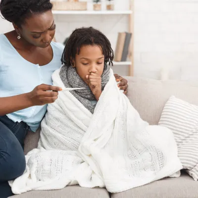 A mother taking her sick child's temperature 