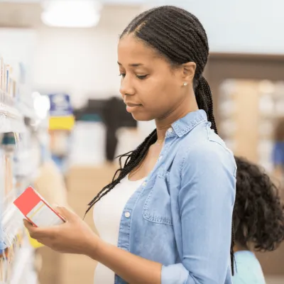 Woman looking at a product at a pharmacy.