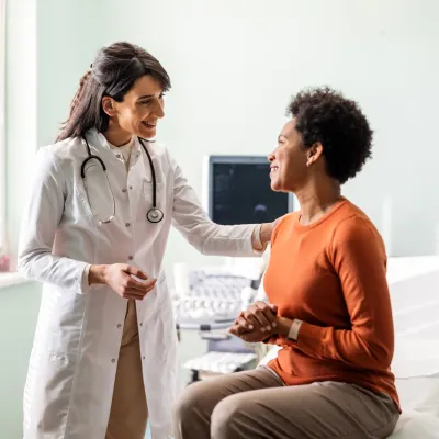 A woman talking with her doctor in an exam in room.