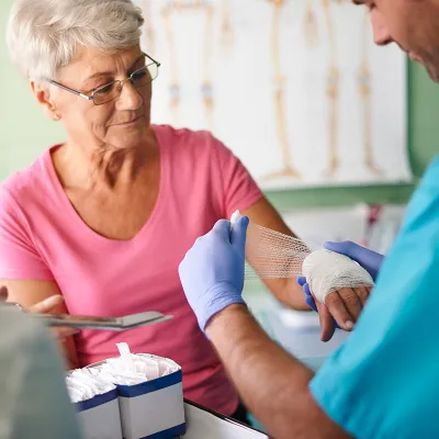 Older Woman Getting Bandage Wrapped on Wound