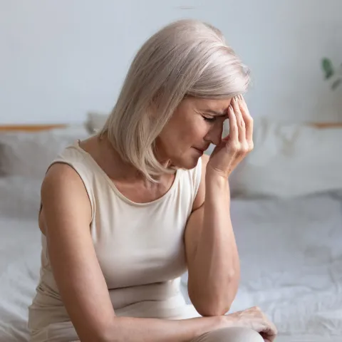 Senior Woman rubbing forehead in pain