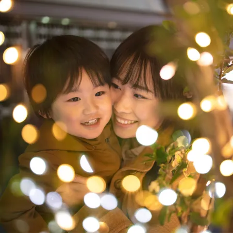 A Mother and Son Enjoy Christmas Lights Outside in the Winter Weather