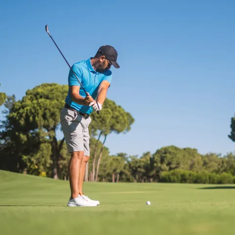 Man playing golf outdoors