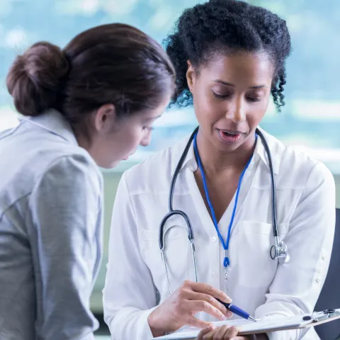 A Physician Goes Over A Chart With Her Patient 