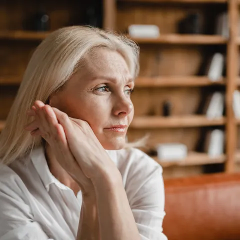 A Woman Thinks Deeply with Her Hand Pressed Against Her Face