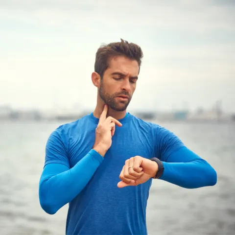 A Man Takes a Break From His Jog to Check His Pulse.