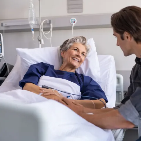 Son visiting sick old mother in hospital