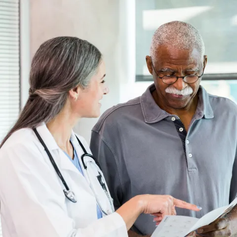 White Doctor Speaking With African American Patient