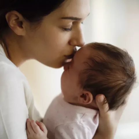 Mother Kissing Baby on Forehead